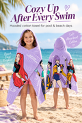Girl wearing a lavender character hooded cotton towel on a sunny beach with the headline Cozy Up After Every Swim.