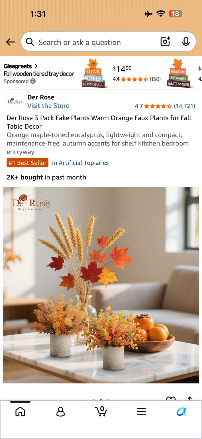 Three warm orange faux fall plants in gray pots.
