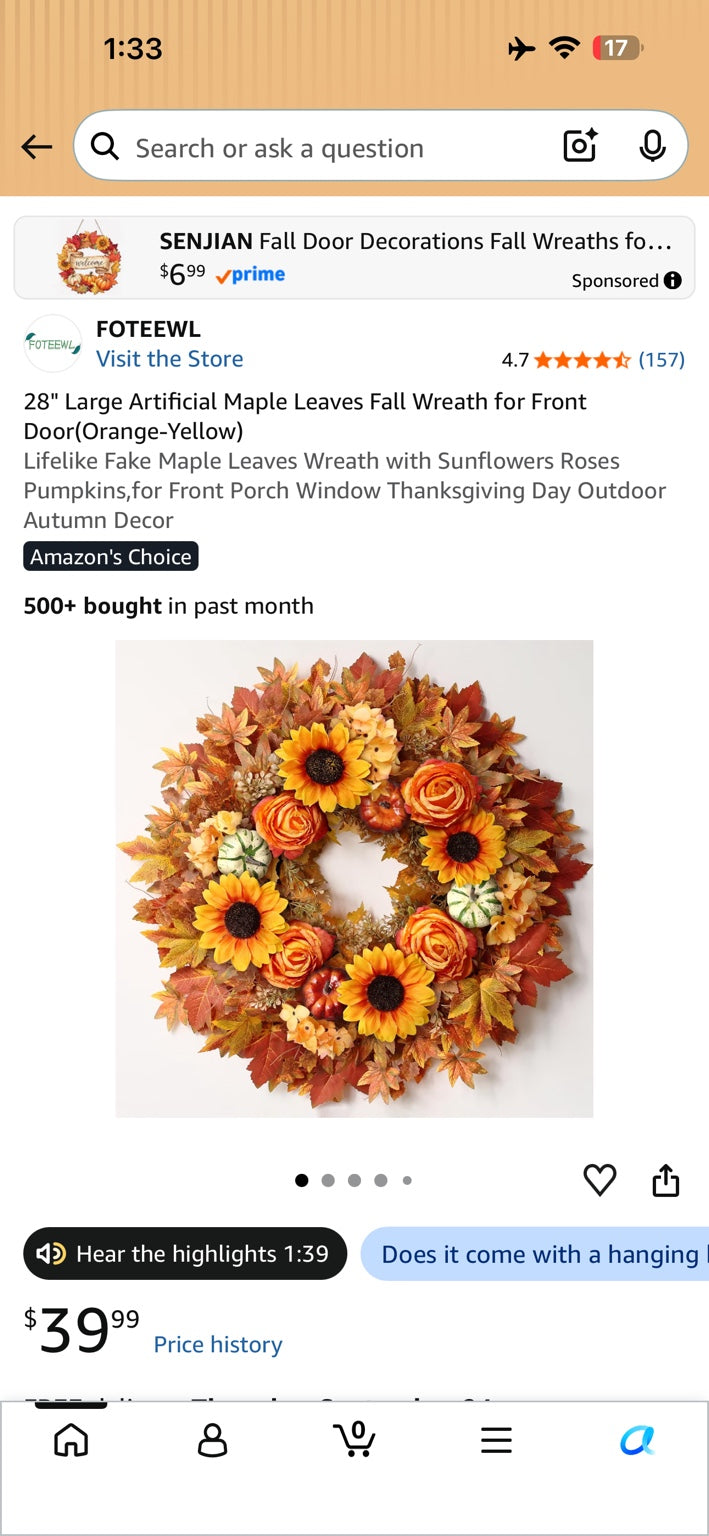 Artificial fall wreath with orange and yellow maple leaves, sunflowers, roses and small pumpkins.