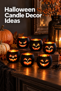 Vertical Halloween lifestyle scene showing six round black jack-o’-lantern candle holders glowing orange on a dark wooden table. Each holder has a different carved-style face, with pumpkins, autumn leaves, berry branches, a black lantern, gauzy fabric, and a small decorative spider around them. Warm candlelight reflects across the tabletop in a dim, cozy room, while large white headline text at the upper left reads “Halloween Candle Decor Ideas.”