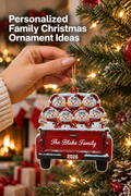 Vertical holiday lifestyle photo of a hand hanging a personalized red pickup-truck Christmas ornament from a frosted evergreen branch beside warm white lights. Seven smiling snowmen in red-and-white hats ride in the truck, with names on their hats, “The Blake Family” across the tailgate, and “2026” below. A blurred fireplace, stockings, wreath, wrapped gifts, red bauble, and pinecones create a cozy background. Headline reads: “Personalized Family Christmas Ornament Ideas.”