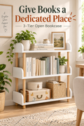 Warm white three-tier open bookcase styled with books and storage in a bright room, with the headline Give Books a Dedicated Place.